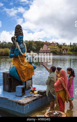 Family offering prayer to Lord Shiva at temple by the holy lake of Grand Bassin, Mauritius. Stock Photo