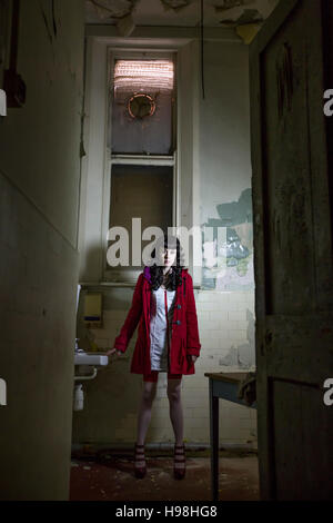 Spooky crazy nurse in derelict old and haunted asylum hospital Stock