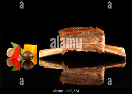 Single roasted back rib with black background Stock Photo