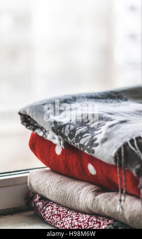a stack of plaids on the windowsill. Stock Photo