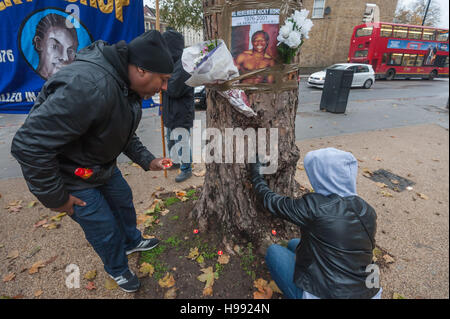 London, UK. 20th November 2016. People put  burning candles around the base of the memorial tree, also known as the lynching tree, outside Brixton Police Station where Ricky Bishop was killed by police officers on 22nd November 2001. Had he lived he would now be 40. The event called for his killers to be jailed, commemorated his memory, called for justice and reparations to his family by the UK government and Lambeth council and for black community control of police.  Peter Marshall/Alamy Live News Stock Photo