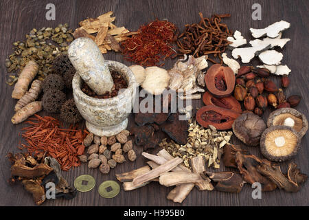 Traditional chinese herbal medicine selection with mortar and pestle on oak background. Stock Photo