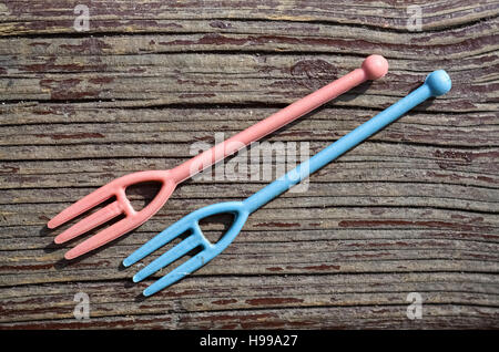 Closeup of two small plastic forks on wooden background Stock Photo
