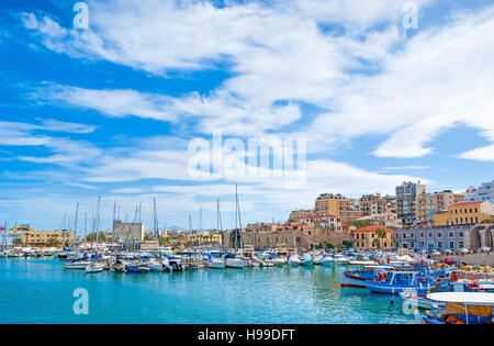 The walk along the harbor of Heraklion with ruins of Venetian era buildings and numerous yachts and boats in port, Crete, Greece. Stock Photo