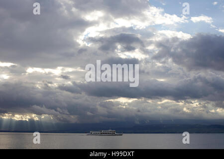 Ferry boat sailing on Lake Geneva under heavy cloud. Stock Photo