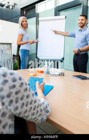Business people analyzing together data on flipchart Stock Photo