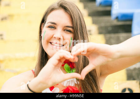 Female soccer fan forming heart with hands Stock Photo