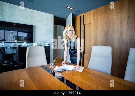 Businesswoman holding documents in board room Stock Photo