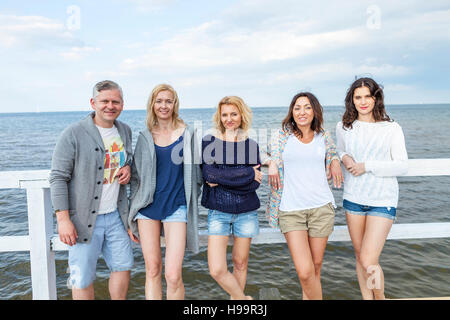 Group of friends relaxing on jetty Stock Photo