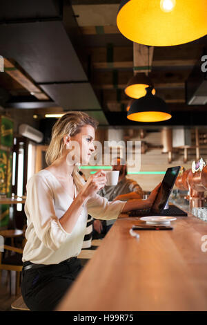 Woman in coffee shop using digital tablet Stock Photo