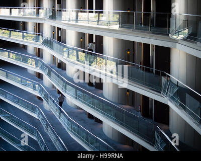 The cleaning squad of a large business hotel is cleaning the hotel floors and rooms. Many rooms on many floors visible. Stock Photo
