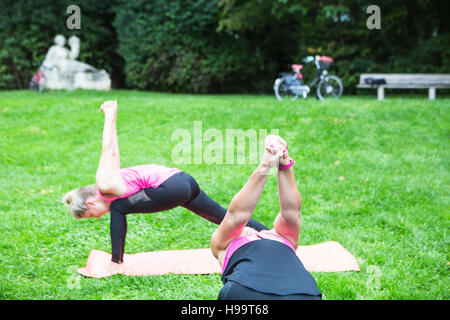 Young women practicing yoga in park Stock Photo
