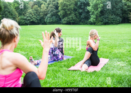 Young women practicing yoga in park Stock Photo