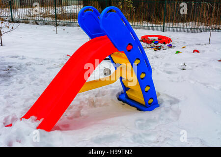 Children's toys covered with snow in the yard of a private house Stock Photo