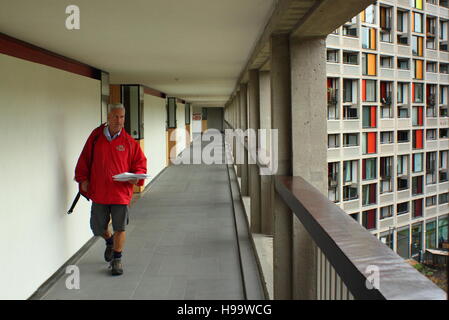 Royal Mail worker delivers post to apartments in a redeveloped flank of Park Hill flats in  Sheffield, Yorkshire, England - 2016 Stock Photo