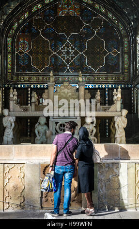 Couple looks at Marble Throne (Takht e Marmar) built in 1806 by order of Fath Ali Shah, part of Golestan Palace in Tehran, Iran Stock Photo