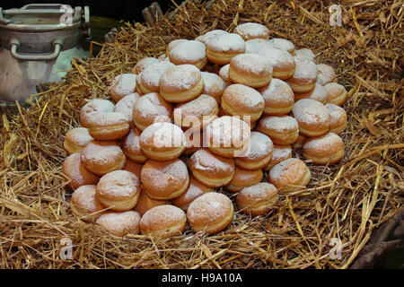 Heap of Fried Bavarian Cream Filled Donuts on Bed of Straw Stock Photo
