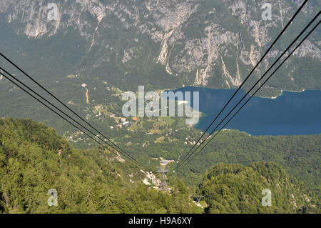 Looking down the alpine cable car to the village of Ukanc on the shore of Lake Bohinj, Slovenia, from Mount Vogel Stock Photo