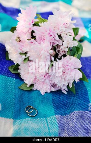 wedding rings on a background of a beautiful wedding bouquet Stock Photo