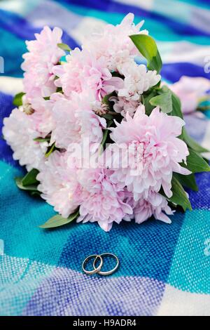 wedding rings on a background of a beautiful wedding bouquet Stock Photo