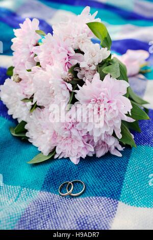 wedding rings on a background of a beautiful wedding bouquet Stock Photo