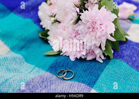 wedding rings on a background of a beautiful wedding bouquet Stock Photo