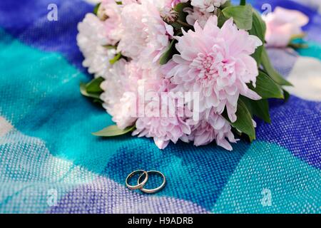 wedding rings on a background of a beautiful wedding bouquet Stock Photo