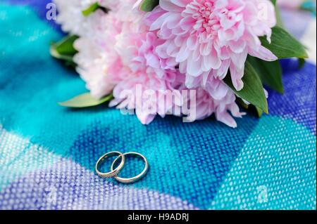 wedding rings on a background of a beautiful wedding bouquet Stock Photo