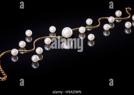 White pearls necklace on black background. Focus on the big pearl! Stock Photo