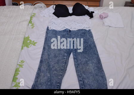 Female's outfit neatly laid out on bed Stock Photo