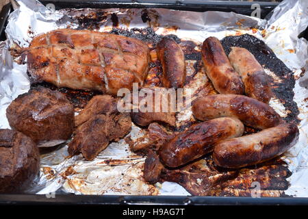 Variety of meat on tin foil in a baking tray Stock Photo