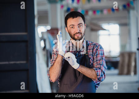Portrait of a carpenter working in workshop wearing gloves Stock Photo