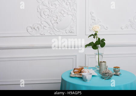 croissant and white rose on a table against luxury wall, copy space Stock Photo