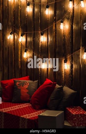 Deer head on red hand made pillow wooden background in interior Stock Photo