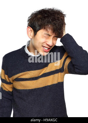 Closeup portrait, stressed young asian man, hands on head with bad headache, isolated background on white. Negative human emotion facial expression fe Stock Photo