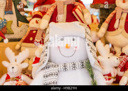 Display of soft toy snowmen and reindeer on festive market stall Stock Photo