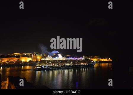 The Mein Schiff 3 cruise ship, operated by TUI, as it was departing the Grand Harbour in Malta at night time Stock Photo