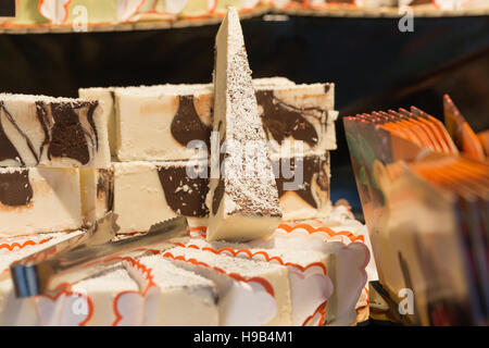 Close up artisan farmers market display of chocolate cream cheese cake piled high with tongs Stock Photo