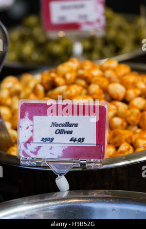 Olives and deli treats in silver bowls with signs and prices, fresh produce at farmers christmas market Stock Photo