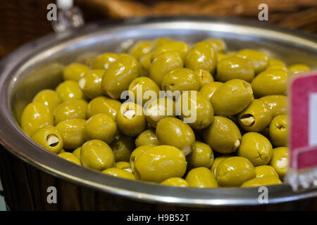 Green stuffed olives in silver bowl, fresh produce at farmers christmas market Stock Photo