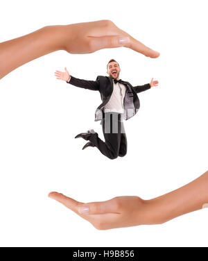 Confident Smart Looking Man Laughing and Jumping Up, Enjoying Protection and insurance in the hands of Young Woman,  on white Background Stock Photo