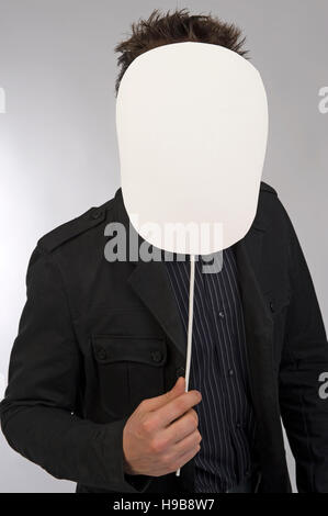 Young man holding blank shield in front of his face Stock Photo