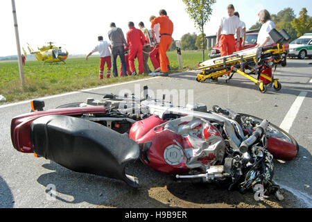 Wrecked motorcycle on road, traffic accident, casualty being taken to helicopter by rescue service, Markt Swabia, Upper Bavaria Stock Photo