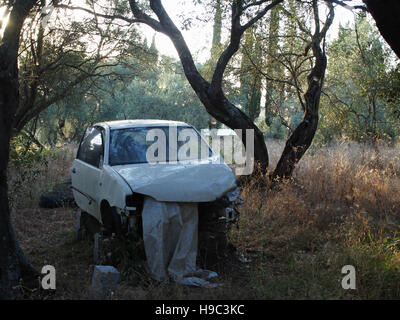 Old car abandoned in olive grove above Xanthates village, Corfu, Greece Stock Photo