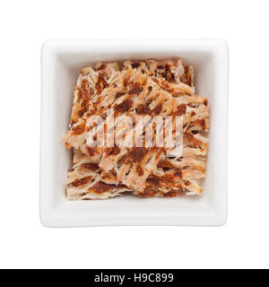 Pieces of grilled dried squid snack in a square bowl isolated on white background Stock Photo