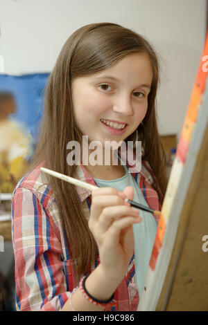 Young artist student girl smiling happy painting sitting on desk at art ...