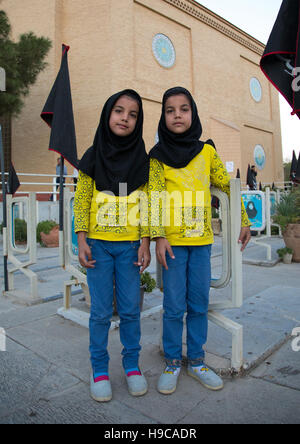 Portrait of iranian shiite twin girls in the rose garden of martyrs cemetery, Isfahan province, Isfahan, Iran Stock Photo