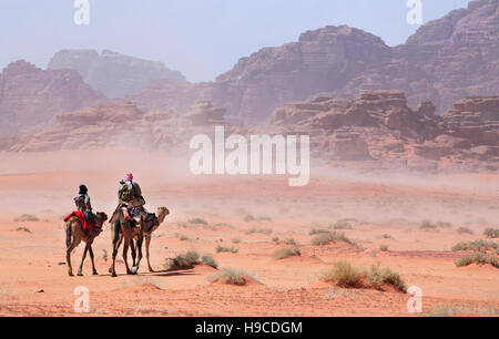 People on camels going through the desert storm Stock Photo