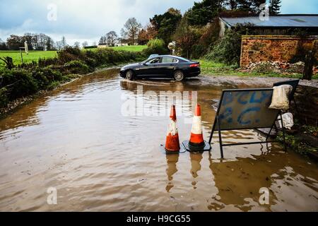 A motorist turns around in flood water on Station Road, Broadclyst, Devon, where rivers have burst their banks and closed the main roads south of the village. Stock Photo