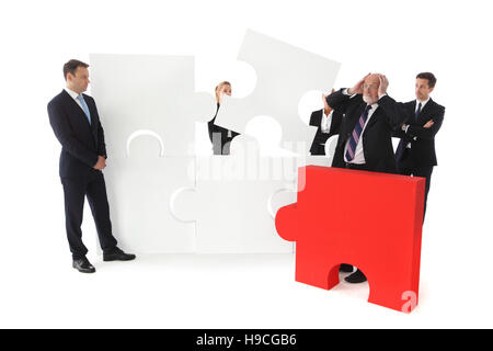 Group of business people assembling pieces of a puzzle isolated on white background Stock Photo